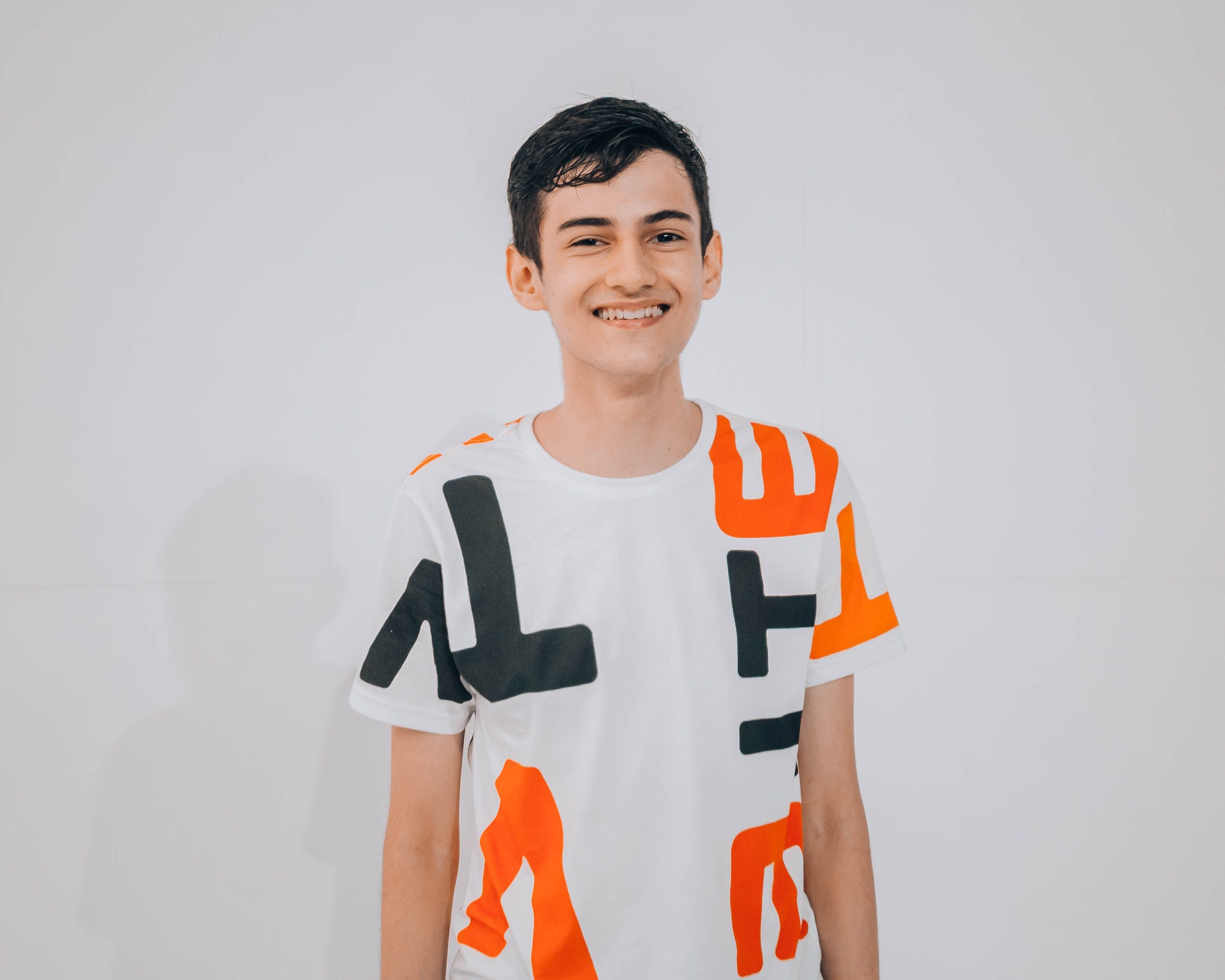 Smiling teen wearing a white graphic t-shirt with a bold abstract orange and black print